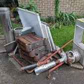 Bulk scrap metal collection and recycling service with trucks and metal piles