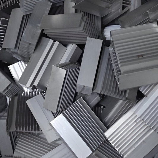 Pile of gray metal heat sinks on a wooden surface